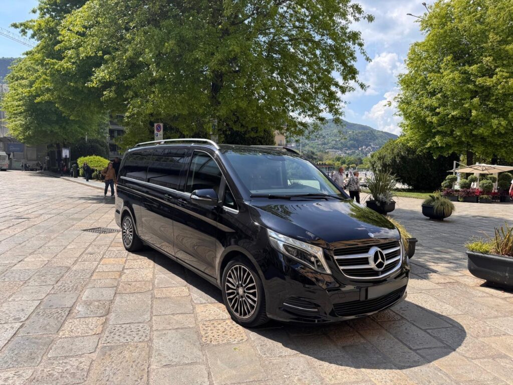 Black Mercedes van for private transfers overlooking Lake Como, offering scenic and exclusive chauffeur-driven travel.